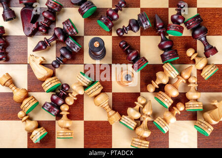 Une photo prise à la verticale d'une situation d'échecs en échec et mat avec presque tous les morceaux tombés sur l'échiquier Banque D'Images