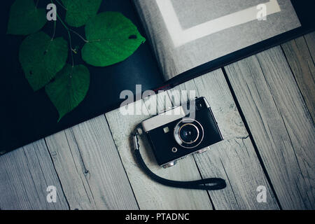 Vintage camera, un vieil album photo sur l'arrière-plan en bois blanc Banque D'Images