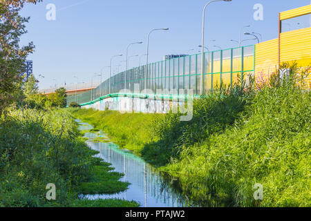 Écrans absorbant le long de la route et le ruisseau.en métal rempli de verre et panneaux insonorisant jaune.La technologie moderne en Pologne. Banque D'Images