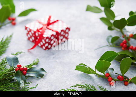 Décorations de Noël, des feuilles de houx avec les fruits rouges. Le houx (Ilex aquifolium européenne) Feuilles et fruits. Banque D'Images