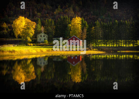 Belles réflexions du petit village sur les rives du lac en couleurs automnales. Dans Nydammen Ranheim Lake, la Norvège. Banque D'Images