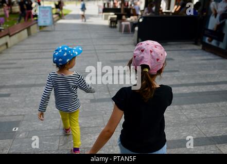 Les enfants marchant le long d'une rue de ville, le marché de clavettes sur Flinders Street, Central Business District de la ville de Townsville QLD, Australie Banque D'Images