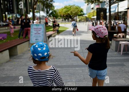 Les enfants marchant le long d'une rue de ville, le marché de clavettes sur Flinders Street, Central Business District de la ville de Townsville QLD, Australie Banque D'Images