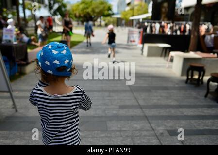 Les enfants marchant le long d'une rue de ville, le marché de clavettes sur Flinders Street, Central Business District de la ville de Townsville QLD, Australie Banque D'Images