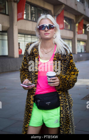 LONDON, UK- 14 septembre 2018 : les gens dans la rue au cours de la London Fashion Week. Blonde girl in pink T-shirt, short vert et fausse fourrure léopard coa Banque D'Images