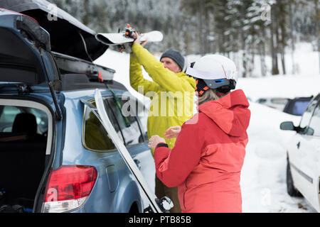 Senior couple gardant un ski sur toit de voiture Banque D'Images