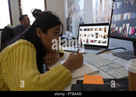 De travail exécutif femelle sur journal in office Banque D'Images