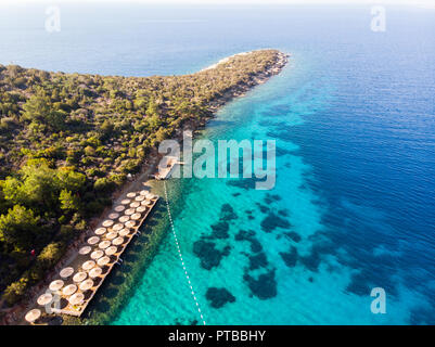 Vue aérienne de la plage presqu'île Cove avec chaises longues bleu de la mer et les arbres à Bodrum Turquie Yali. Locations Banque D'Images