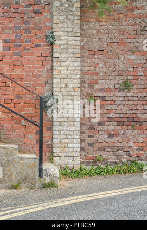 Marches avec main courante métallique devant l'ancien mur limite d'un hôtel à Newquay, en Cornouailles. Banque D'Images