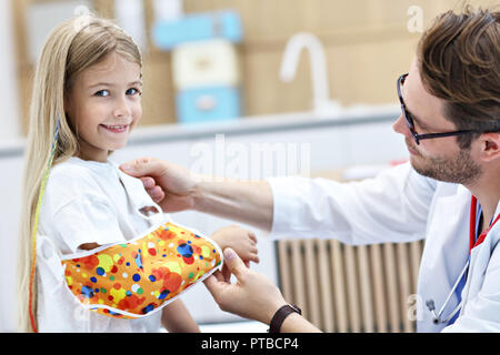 Photo de l'homme contrôle de pansement pédiatre little girl's bras cassé Banque D'Images