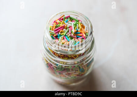 Pot de sucre coloré arrose en bouteille en verre. La confiserie. Banque D'Images