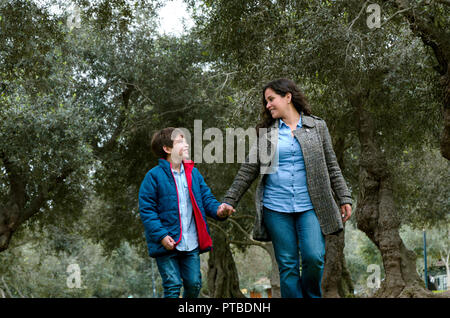 Mère va avec son fils marcher dans le parc en automne Banque D'Images