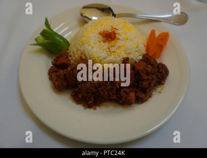 Poulet Fesenjan azerbaïdjanais sur une assiette avec du riz et de concombre Sauce Noix de Grenade Banque D'Images