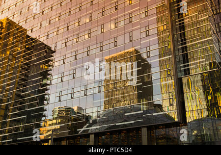 SEATTLE, WA, USA, - Juin 2018 : réflexions dans un immeuble de bureaux en verre dans le centre-ville de Seattle au coucher du soleil. Banque D'Images