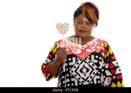 Studio shot of fat black African woman holding heart shaped loll Banque D'Images