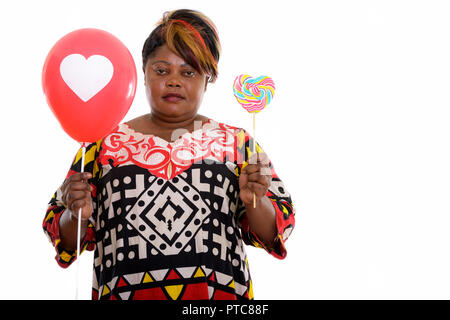 Studio shot of fat black African woman holding heart shaped loll Banque D'Images