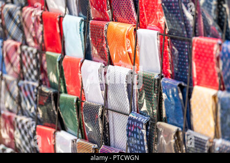 Profil de gros plan de nombreux liens avec des couleurs vibrantes couleurs cravates, emballés dans du plastique, sur l'affichage dans la rue du marché commercial à Firenze, Florence, Italie i Banque D'Images