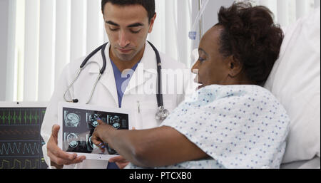 Portrait of Hispanic médecin montrant ct-scans sur tablet au patient Banque D'Images