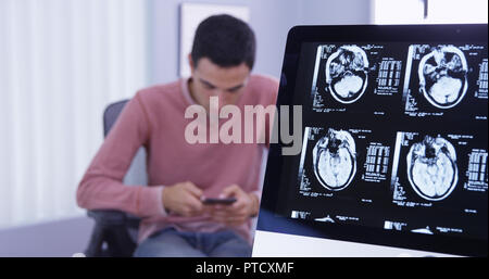 Tdm du patient sur ordinateur alors qu'il utilise pour envoyer des messages texte Banque D'Images