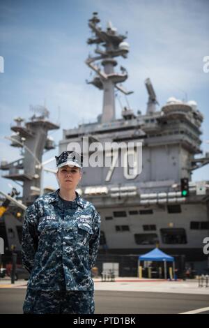 CORONADO, Californie (8 juillet 2017) ---électricien Aviation 2e classe Marianne DeSilva, affecté à l'Escadron d'hélicoptères de combat de la mer 4 (CSS-4),et une partie de la grève, Carl Vinson Groupe pose devant le transporteur après un retour de récemment 5 mois de déploiement de longue durée. Banque D'Images