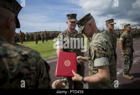 Le Caporal des Marines des États-Unis. Eric Goodman reçoit une médaille d'excellence de la Marine depuis le colonel Forrest Poole Camp à bord Kinser, Okinawa, Japon, Juillet 11, 2017. Goodman était l'un des cinq marines pour aider une femme japonaise locale sur son chemin vers le bas le Mont Fuji, au Japon, le 3 juillet 2017. La femme, le ministère de l'APD, a été trouvé sur le sol, l'hyperventilation et de la difficulté à respirer quand les marines sont venus à son aide. Ensemble, ils ont créé une civière de fortune pour transporter son sur environ deux kilomètres avant d'arriver à l'assistance médicale. Goodman, 26 ans, Grass Valley, en Californie, est un réparateur radio au sol avec Banque D'Images