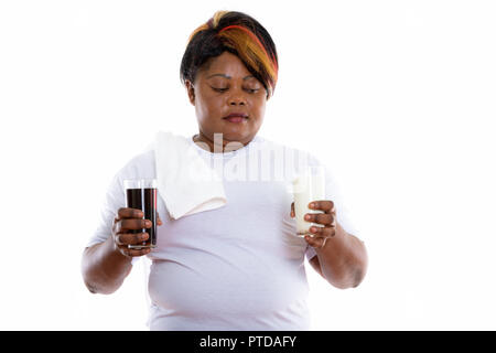 Studio shot of fat black African woman holding glass of soda dri Banque D'Images