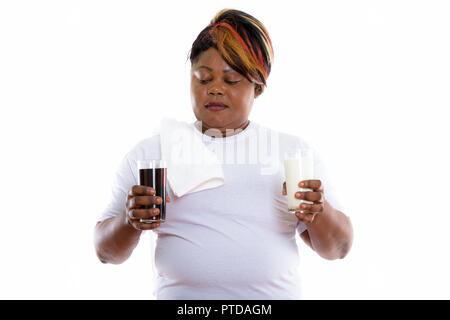 Studio shot of fat black African woman looking at verre de soda Banque D'Images