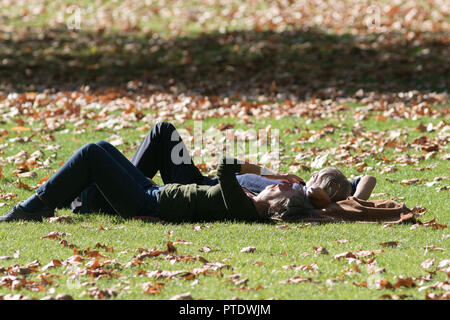 London UK. 9e Ocrober 2018. Les gens et faire une sieste au soleil dans l'après-midi ensoleillé de Saint James's Park couvert de feuilles tombées sur une chaude journée d'automne en octobre devrait être le mois le plus chaud en sept ans que l'été indien renvoie Crédit : amer ghazzal/Alamy Live News Banque D'Images