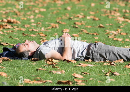 London UK. 9e Ocrober 2018. Les gens et faire une sieste au soleil dans l'après-midi ensoleillé de Saint James's Park couvert de feuilles tombées sur une chaude journée d'automne en octobre devrait être le mois le plus chaud en sept ans que l'été indien renvoie Crédit : amer ghazzal/Alamy Live News Banque D'Images