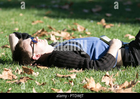 London UK. 9e Ocrober 2018. Les gens et faire une sieste au soleil dans l'après-midi ensoleillé de Saint James's Park couvert de feuilles tombées sur une chaude journée d'automne en octobre devrait être le mois le plus chaud en sept ans que l'été indien renvoie Crédit : amer ghazzal/Alamy Live News Banque D'Images