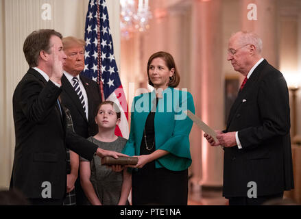 Comme sa famille et le Président des Etats-Unis, Donald J. Trump regardez sur la justice, de la Cour suprême Brett Kavanaugh prend le serment judiciaire de l'ex-juge de la Cour suprême Anthony M. Kennedy lors d'une cérémonie d'assermentation dans l'East Room de la Maison Blanche à Washington, DC le lundi 8 octobre 2018. Kavanaugh a officiellement prêté serment le samedi, quelques heures après qu'il a été confirmé par le Sénat américain. Credit : Ron Sachs/CNP (restriction : NO New York ou le New Jersey Journaux ou journaux dans un rayon de 75 km de la ville de New York) dans le monde entier d'utilisation | Banque D'Images