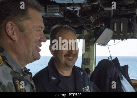 Mer de Corail (14 juillet 2017) Le capitaine Larry McCullen (droite), commandant de l'assaut amphibie USS Bonhomme Richard (DG 6), parle avec Marine royale australienne Le Capitaine Guy Holthouse, commandant du combat naval pour le Talisman Saber 2017 Force amphibie combinée, sur la passerelle du navire pendant 17 Sabre Talisman. Bonhomme Richard, fait partie d'une U.S.-groupe expéditionnaire Australie-Nouvelle-Zélande, subit une série de scénarios qui permettront d'accroître les compétences de la marine dans l'exploitation de l'eau contre les menaces et de confrontation dans sa mission première de lancement maritime forces à terre dans la Banque D'Images