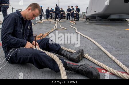 Inde (14 juillet 2017) Seaman AJ Daugherty, Ville de Thunder Bay, Canada, prépare pour l'arrimage de la ligne comme la classe Ticonderoga croiseur lance-missiles USS Princeton (CG 59) est en cours pour la phase en mer de Malabar en 2017. 2017 Malabar est la dernière d'une série d'exercices entre la marine indienne, l'auto-défense maritime du Japon et de la Marine qui a pris de l'ampleur et de la complexité au fil des ans pour répondre à la variété des menaces communes à la sécurité maritime dans l'Indo-Asia pacifique. Banque D'Images