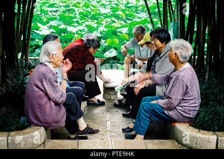 Xi'an / Chine - 24 juin 2011 : chinese man and woman playing cards et de parler dans un parc à côté d'un petit étang Banque D'Images