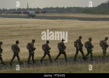 Plusieurs pays de l'OTAN de parachutistes à pied vers un U.S. Air Force C-130J Super Hercules à bord pendant la Semaine internationale Jump plus de Bitburg, en Allemagne, Juillet 11, 2017. Environ 500 militaires de plus de 13 pays partenaires ont participé à cette année de formation. Banque D'Images