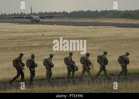 Plusieurs pays de l'OTAN de parachutistes à pied vers un U.S. Air Force C-130J Super Hercules à bord pendant la Semaine internationale Jump plus de Bitburg, en Allemagne, Juillet 11, 2017. Environ 500 militaires de plus de 13 pays partenaires ont participé à cette année de formation. Banque D'Images