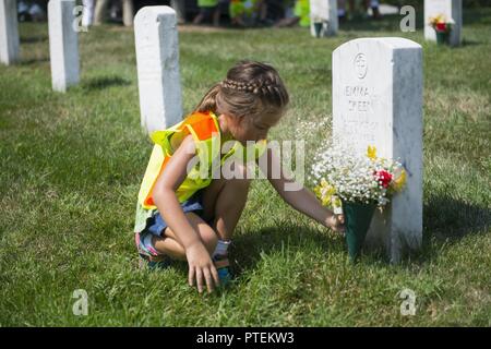 Bell Makenna jette des fleurs sur une tombe dans l'article 21 du Cimetière National d'Arlington, Arlington, Va., le 17 juillet 2017. Plus de 400 professionnels ont participé à paysage bénévole l'Association nationale des professionnels du paysage et de renouvellement annuel 21 souvenir à l'ANC. Banque D'Images