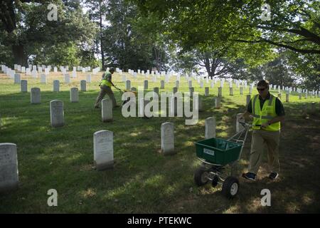 Jeter les bénévoles de la chaux dans l'article 31 de cimetière National d'Arlington, Arlington, Va., le 17 juillet 2017. Plus de 400 professionnels ont participé à paysage bénévole l'Association nationale des professionnels du paysage et de renouvellement annuel 21 souvenir à l'ANC. Banque D'Images