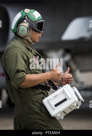 Le Corps des Marines des États-Unis. Alex Velasquez, un technicien des télécommunications et de la navigation maritime avec Fighter Attack Squadron (VMFA) 232, donne le bon-à-Passer à F/A-18C Hornet Pilotes prépare à décoller à Japan Air Self-Defense Force (JASDF) Hyakuri Air Base, Japon, Juillet 10, 2017. VMFA-232 a été d'effectuer des exercices avec la JASDF dans le cadre de la formation de l'aviation, du programme de réinstallation qui est conçu pour accroître l'efficacité et l'interopérabilité entre les forces américaines et japonaises. Il réduit les effets du bruit local en dispersant des chasseurs à réaction unilatérale de formation les forces américaines au Japon. Banque D'Images