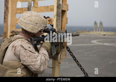 Golfe d'ADEN (16 juillet 2017) U.S. Marine Corps Lance Cpl. Justin Lucas avec 3e Bataillon, 6e feux Marines un M4A1 Carbine sur le pont du USS Carter Hall (LSD 50), le golfe d'Aden, le 18 juillet 2017, au cours d'un exercice de tir réel. La 24e unité expéditionnaire de Marines est actuellement déployée dans la 5e flotte américaine zone d'opérations à l'appui d'opérations de sécurité maritime visant à rassurer les alliés et les partenaires et de préserver la liberté de navigation et la libre circulation du commerce dans la région. Banque D'Images