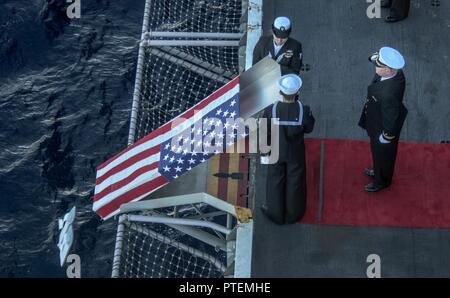 Mer de Corail (15 juillet 2017) Le lieutenant J.G. Jason Burchell, droit, d'un aumônier à bord de la Marine a l'avant-porte-avions déployés, USS Ronald Reagan (CVN 76), rend hommage au maître de Manœuvre 2e classe Richard Jojola, bas, à partir d'Albuquerque, N.M., et maître de Manœuvre 3 Classe Tiffany Stiers, de Kansas City, Mo., engager les cendres de Julius 'Harry' Frey pendant un enterrement en mer cérémonie pour Frey et son épouse, Jerry, au cours de Sabre 2017 Talisman. Frey, un ancien combattant de la Seconde Guerre mondiale, a servi à bord du porte-avions USS Lexington (CV 2) au cours de la bataille de la mer de corail et ses cendres ont été mis en terre à la coor Banque D'Images