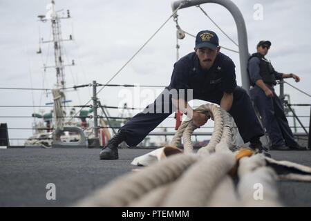 CHENNAI, Inde (13 juillet 2017) Technicien Cryptologic (Collection) 2e classe Felix Vega, de Toronto, Canada, faux dans une ligne que la classe Arleigh Burke destroyer lance-missiles USS Howard (DDG 83) est en cours pour la phase en mer de Malabar en 2017. 2017 Malabar est la dernière d'une série d'exercices entre la marine indienne, l'auto-défense maritime du Japon et de la Marine qui a pris de l'ampleur et de la complexité au fil des ans pour répondre à la variété des menaces communes à la sécurité maritime dans l'Indo-Asia pacifique. Banque D'Images