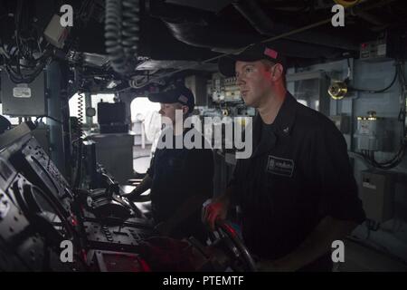 Baie du Bengale (14 juillet 2017) Spécialiste en logistique 3e classe Joseph Gallagher, de Tulsa, Oklahoma, est le timonier regarder à bord du destroyer de classe Arleigh Burke USS Howard (DDG 83) pendant qu'ils sont en cours pour la phase en mer de Malabar en 2017. 2017 Malabar est la dernière d'une série d'exercices entre la marine indienne, l'auto-défense maritime du Japon et de la Marine qui a pris de l'ampleur et de la complexité au fil des ans pour répondre à la variété des menaces communes à la sécurité maritime dans l'Indo-Asia pacifique. Banque D'Images