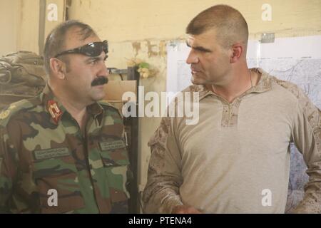 Le brigadier de l'Armée nationale afghane. Le général Ahmadzai, gauche, le commandant général du 215e Corps, parle avec le colonel des marines américain Matthew Grosz, droite, le conseiller supérieur de l'ANA assigné à la Force sud-ouest, au Camp Shorserack, l'Afghanistan, le 14 juillet 2017. Éléments de la Défense nationale afghane et les forces de sécurité, y compris la 215e et 505ème Corps de la Police nationale, la zone effacée avec succès le Nawa centre du district de la présence d'insurgés au cours de l'opération Maiwand quatre avec l'assistance de conseillers en milieu marin, et continuera d'assurer la sécurité et le travail d'établir la gouvernance dans la région. Banque D'Images