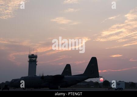 Le soleil se lève sur le C-130H Hercules sur la piste à la 179e Airlift Wing, Mansfield, Ohio, dans la matinée du 19 juillet 2017. La 179e Escadre de transport aérien est toujours pour mission d'être le premier choix pour répondre à la communauté, de l'État fédéral et les missions d'une équipe de confiance d'aviateurs hautement qualifiés. Banque D'Images