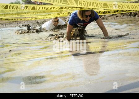 Le colonel William Barrington, 91e commandant du Groupe d'entretien, et le Colonel Catherine Barrington, 91e commandant du Groupe des opérations, à ramper dans la boue à Minot Air Force Base, N.D., 7 juillet 2017. Le vide sanitaire a été l'un des nombreux obstacles qui ont testé l'équilibre des participants, l'endurance et la force. Banque D'Images