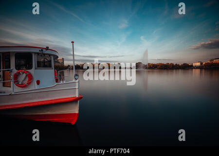 Lac Alster avec vapeur traditionnel bateau pour croisière sur l'eau à Hambourg, Allemagne. Une longue exposition cityscape Banque D'Images