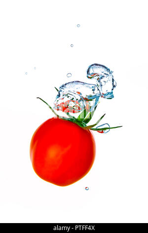 Petite tomate cerise les projections dans l'eau avec des bulles d'air Banque D'Images