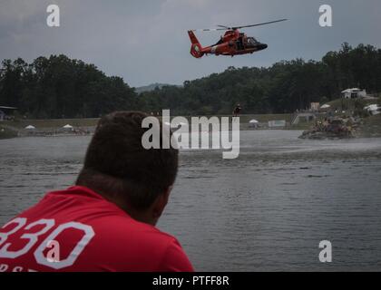 Andrew Reed, une troupe de scouts de la vie 1330 à New Jersey observe son père, le lieutenant de la Garde côtière canadienne le Cmdr. Jamie Reed, un pilote d'Air Station Atlantic City et eagle scout, piloter un hélicoptère MH-65 Dolphin au cours d'une démonstration de survie en eau. Plus de 30 000 scouts, chefs de troupes, les bénévoles et les membres du personnel professionnel, ainsi que plus de 15 000 visiteurs sont attendus à la 2017 Jamboree National. Environ 1 400 militaires du ministère de la Défense nationale et la garde côtière des États-Unis sont de fournir un soutien logistique pour l'événement. Banque D'Images