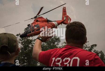 Andrew Reed, une troupe de scouts de la vie 1330 à New Jersey observe son père, le lieutenant de la Garde côtière canadienne le Cmdr. Jamie Reed, un pilote d'Air Station Atlantic City et eagle scout, piloter un hélicoptère MH-65 Dolphin au cours d'une démonstration de survie en eau. Plus de 30 000 scouts, chefs de troupes, les bénévoles et les membres du personnel professionnel, ainsi que plus de 15 000 visiteurs sont attendus à la 2017 Jamboree National. Environ 1 400 militaires du ministère de la Défense nationale et la garde côtière des États-Unis sont de fournir un soutien logistique pour l'événement. Banque D'Images